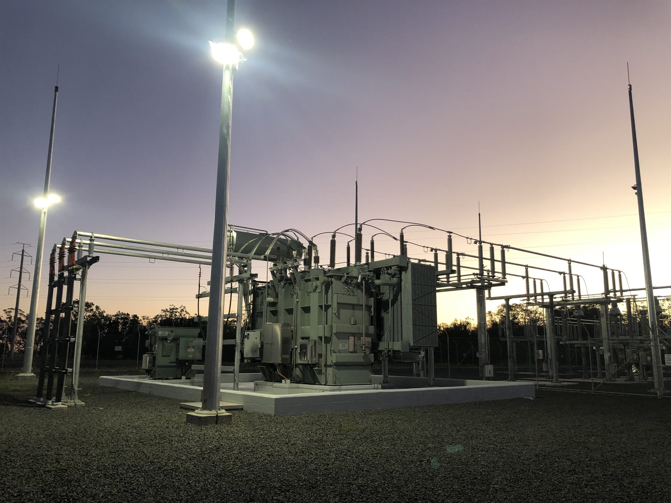 High-voltage transformer and switchyard at dusk